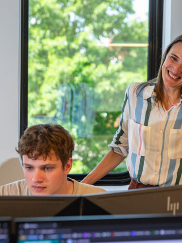 Vrouw met twee jongens achter laptop